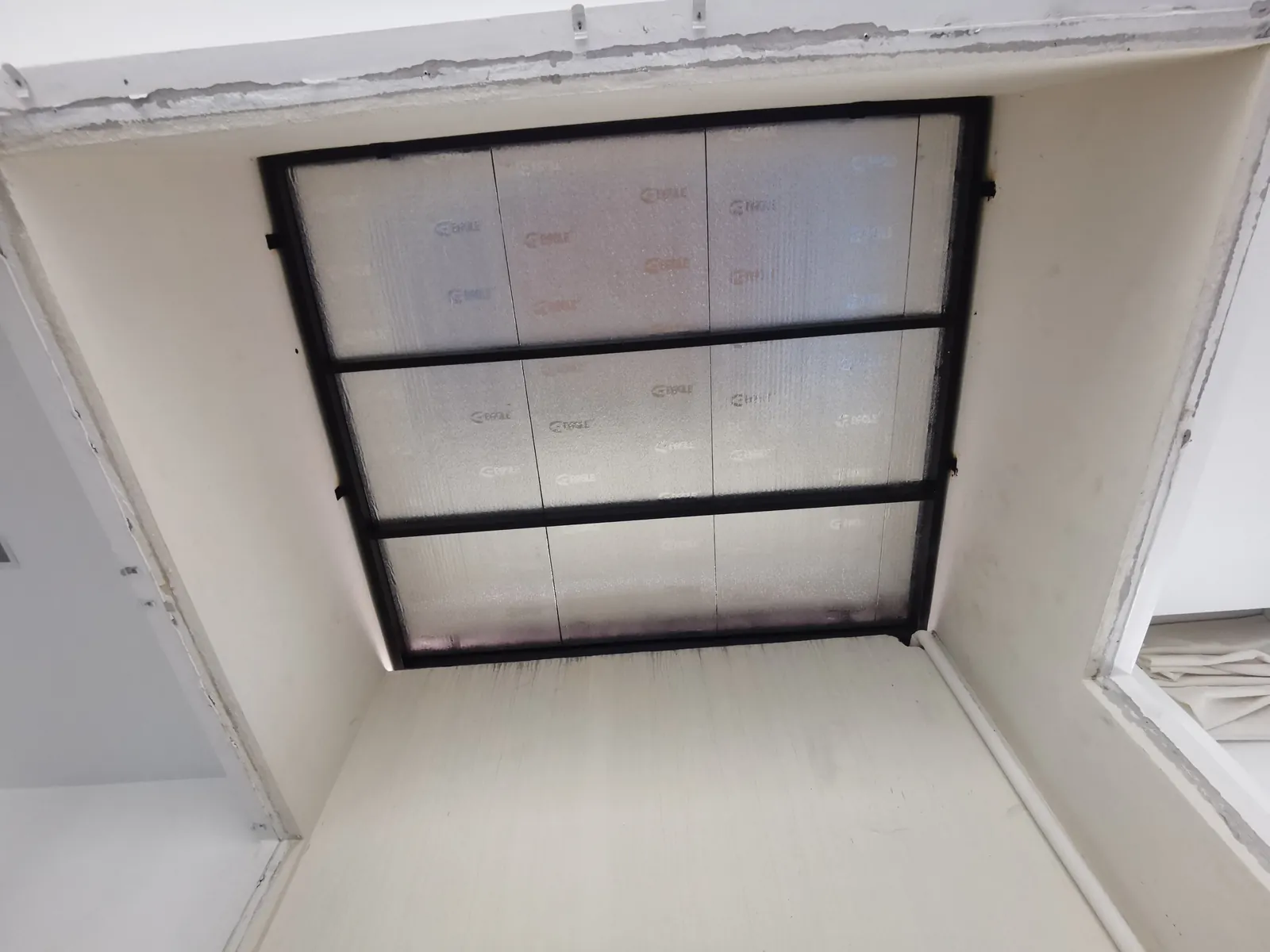 Reflective insulation panels fitted into a ceiling awning grid